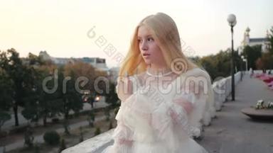 美丽的白种人少女穿着白色的<strong>风衣</strong>，在日落时走在街上。 化妆的审美时尚模特